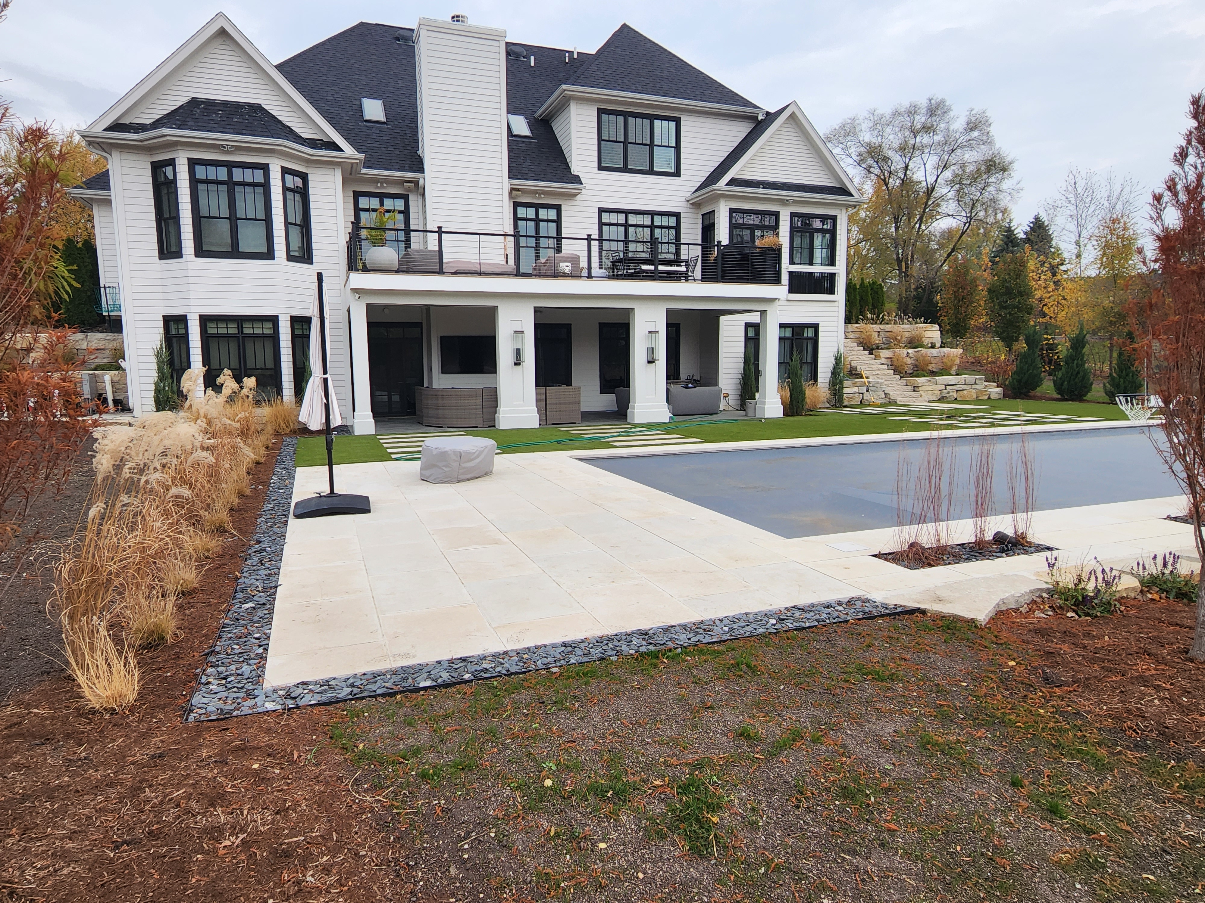 Luxury backyard with pool, paver patio, and turf